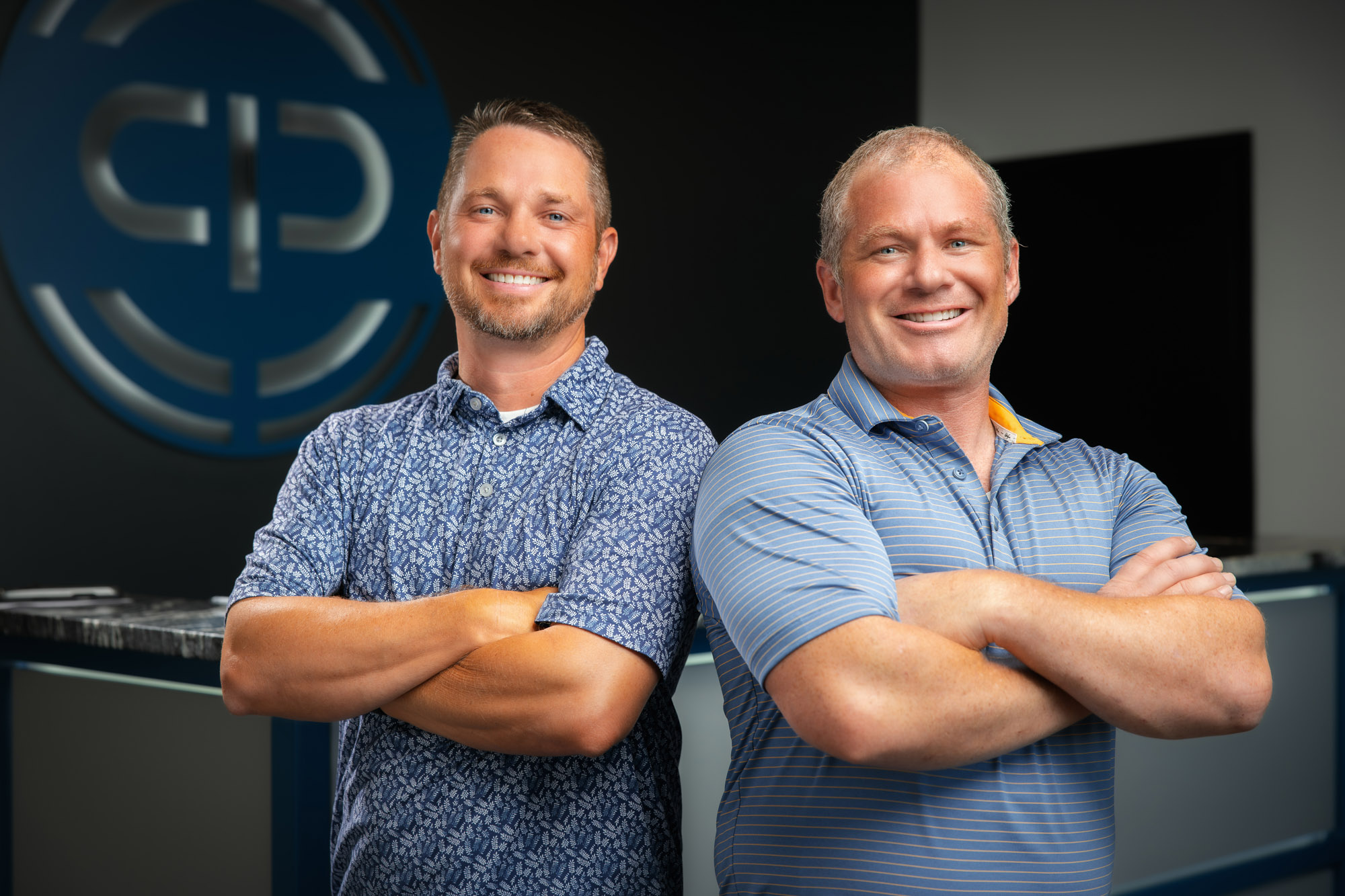 Two smiling men in a corporate office.