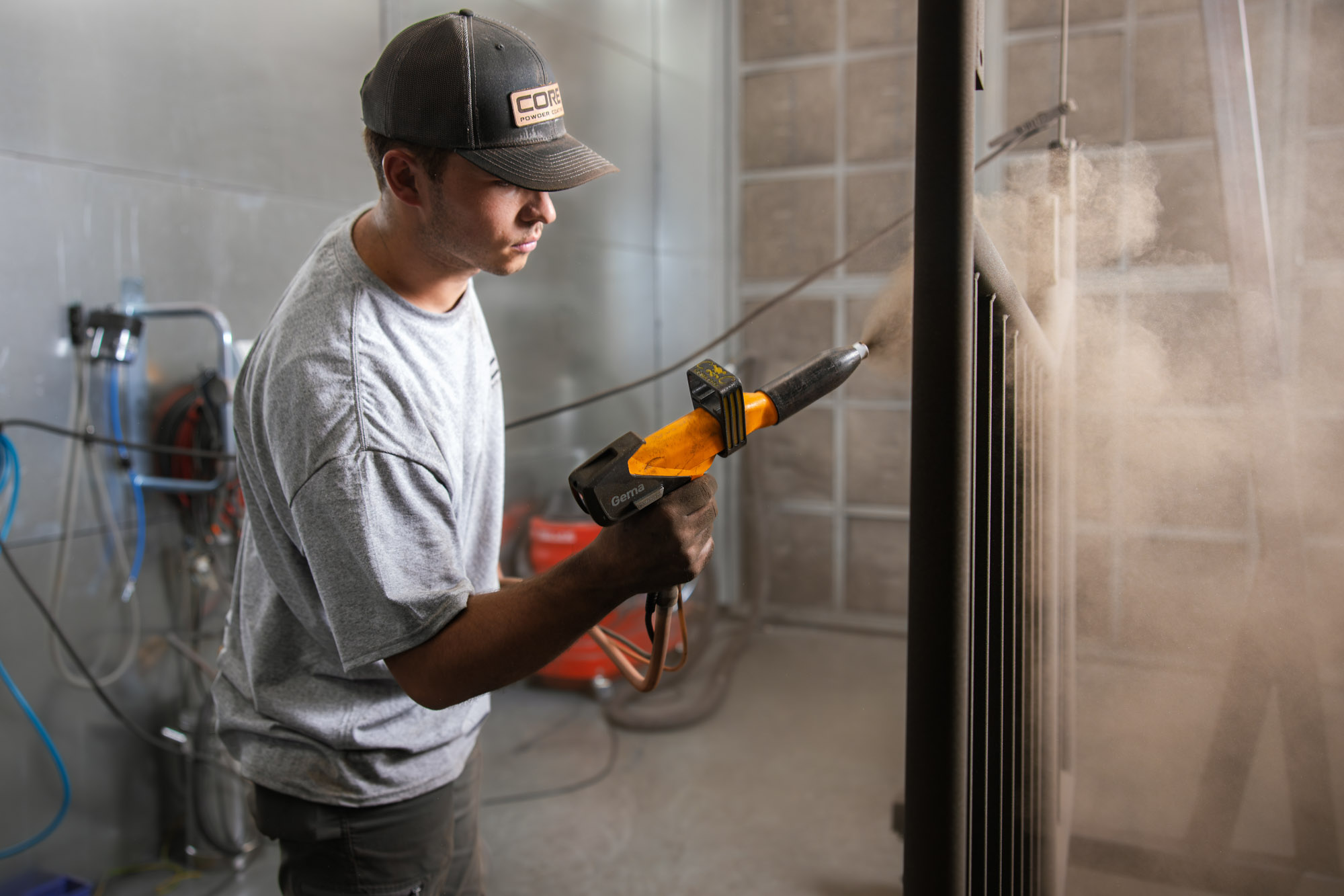 Worker using a spray gun for painting metal