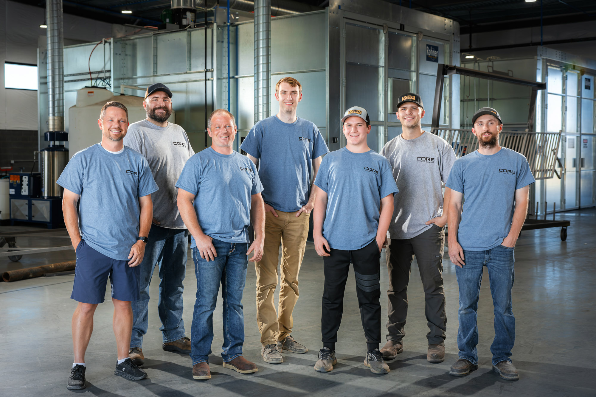 Group of men in industrial workshop setting.