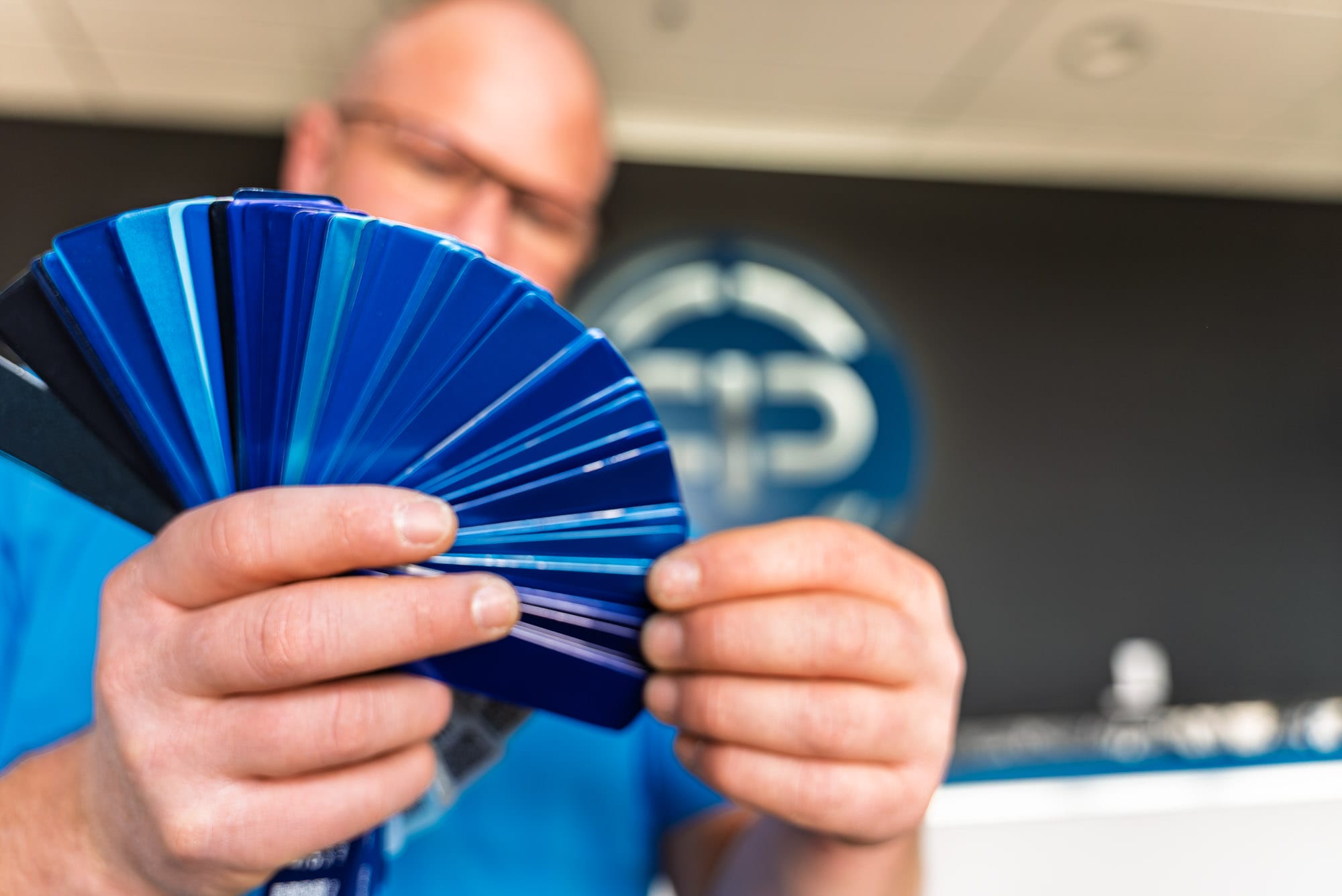 Man holding blue paint color swatches fan deck