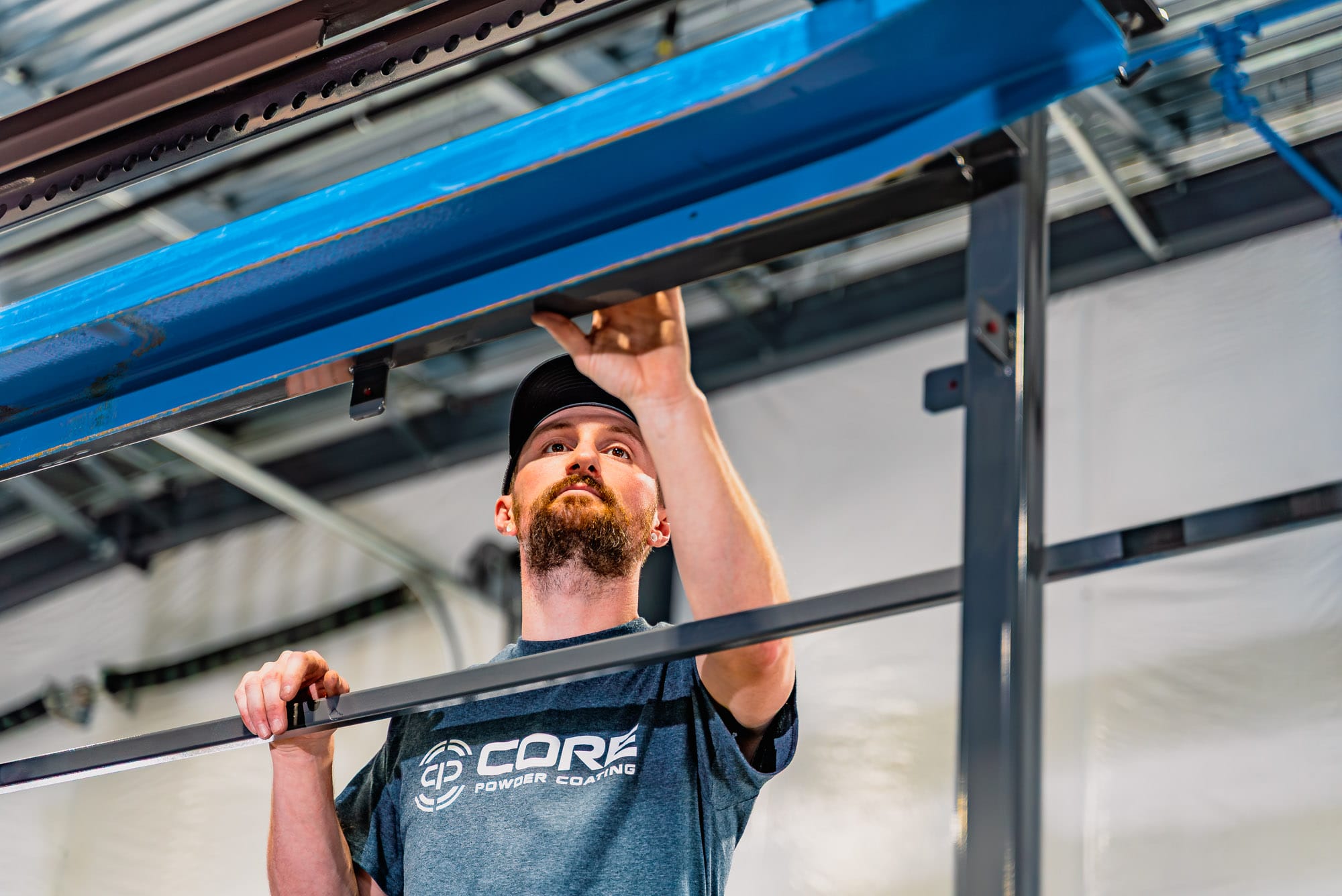 Worker adjusting metal frame in industrial facility