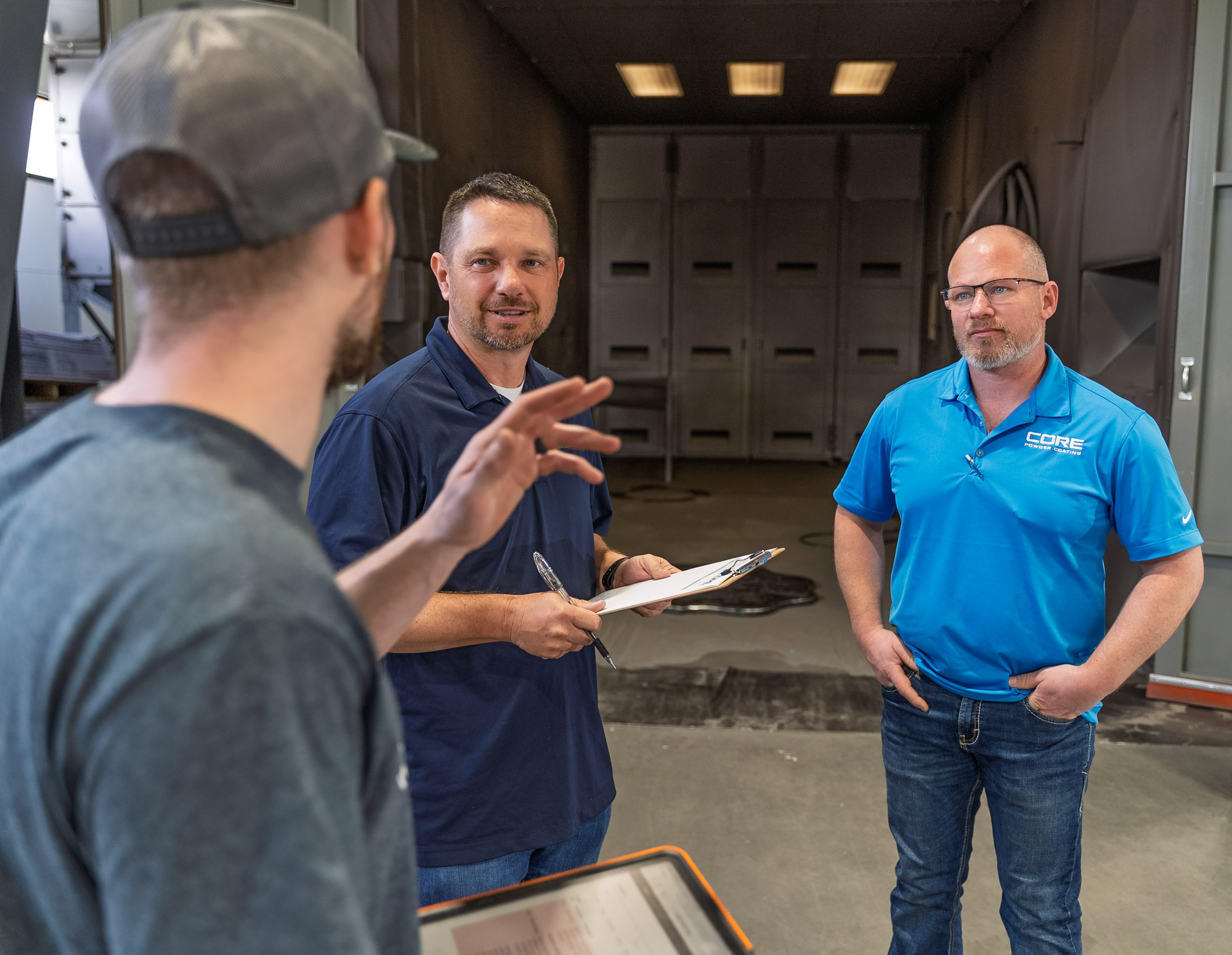 Three men discussing project in industrial facility