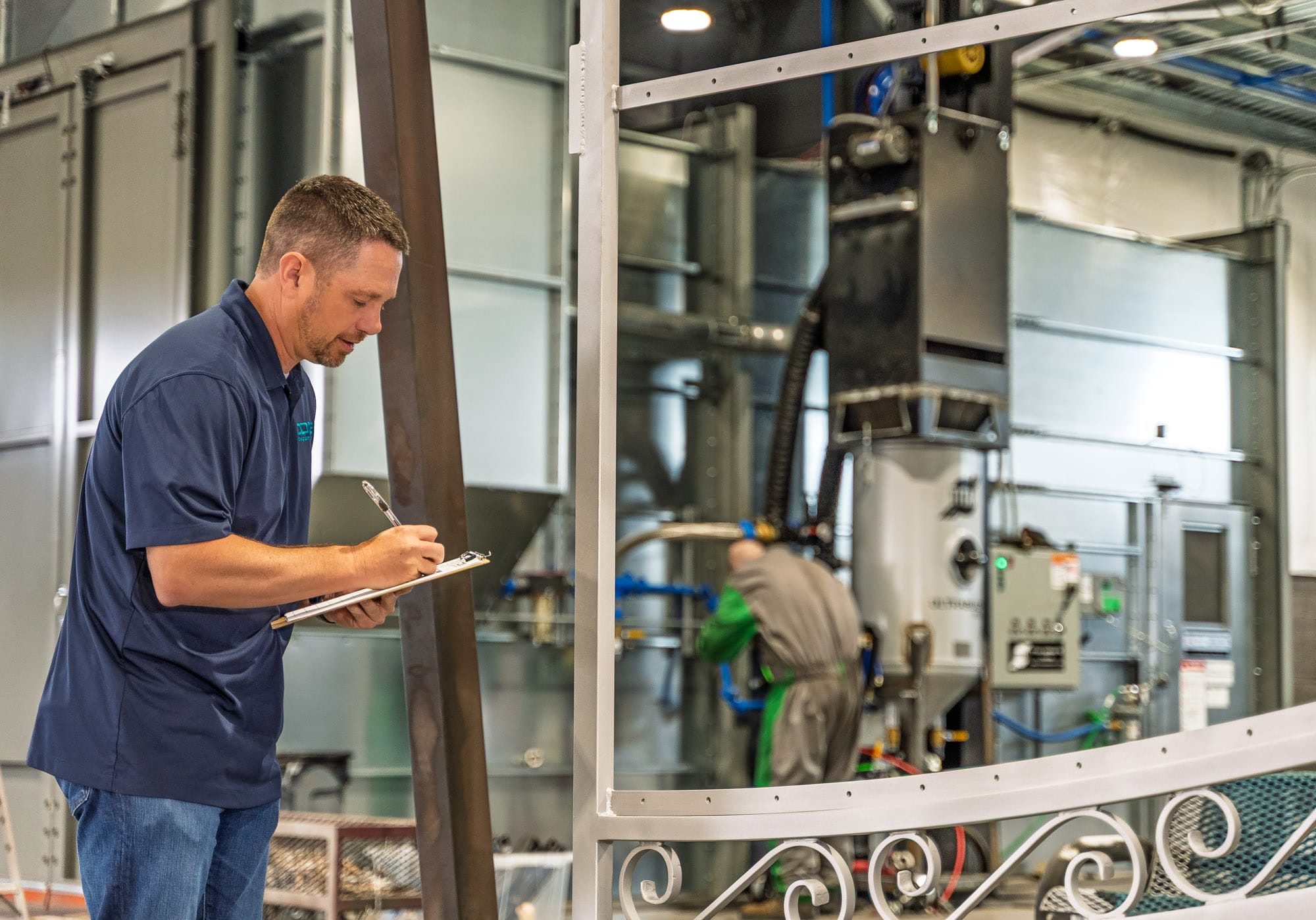 Technician writing on clipboard in industrial facility.