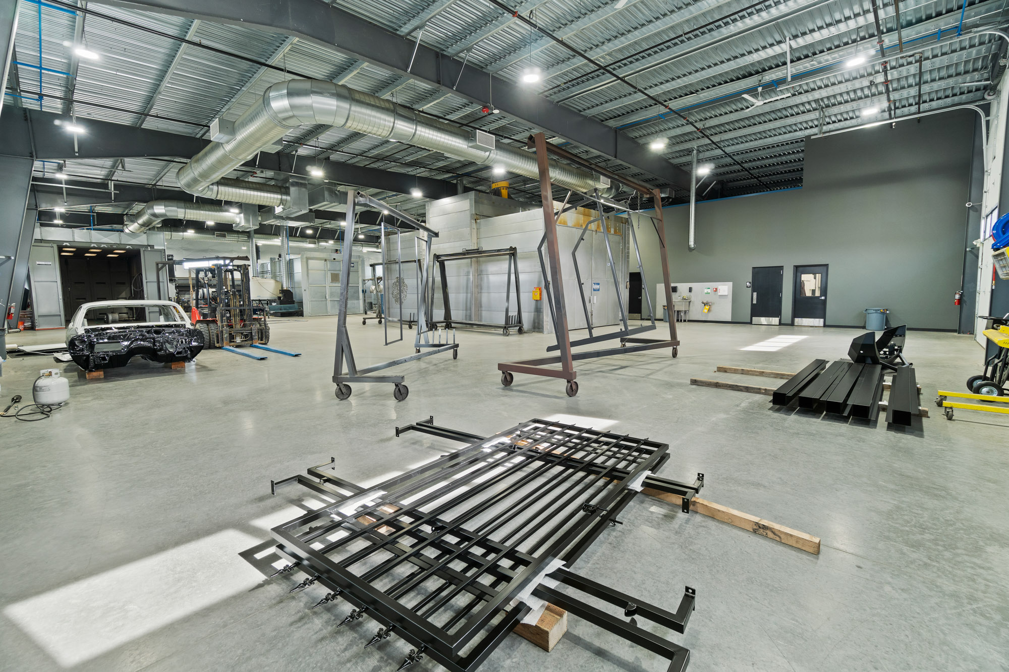 Spacious industrial workshop with metal frames and car body