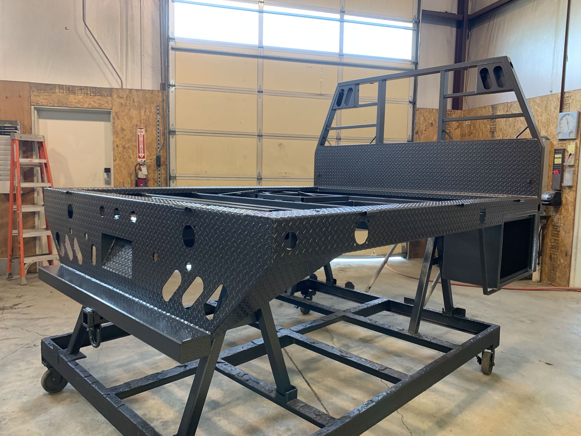 Custom steel flatbed truck bed in workshop
