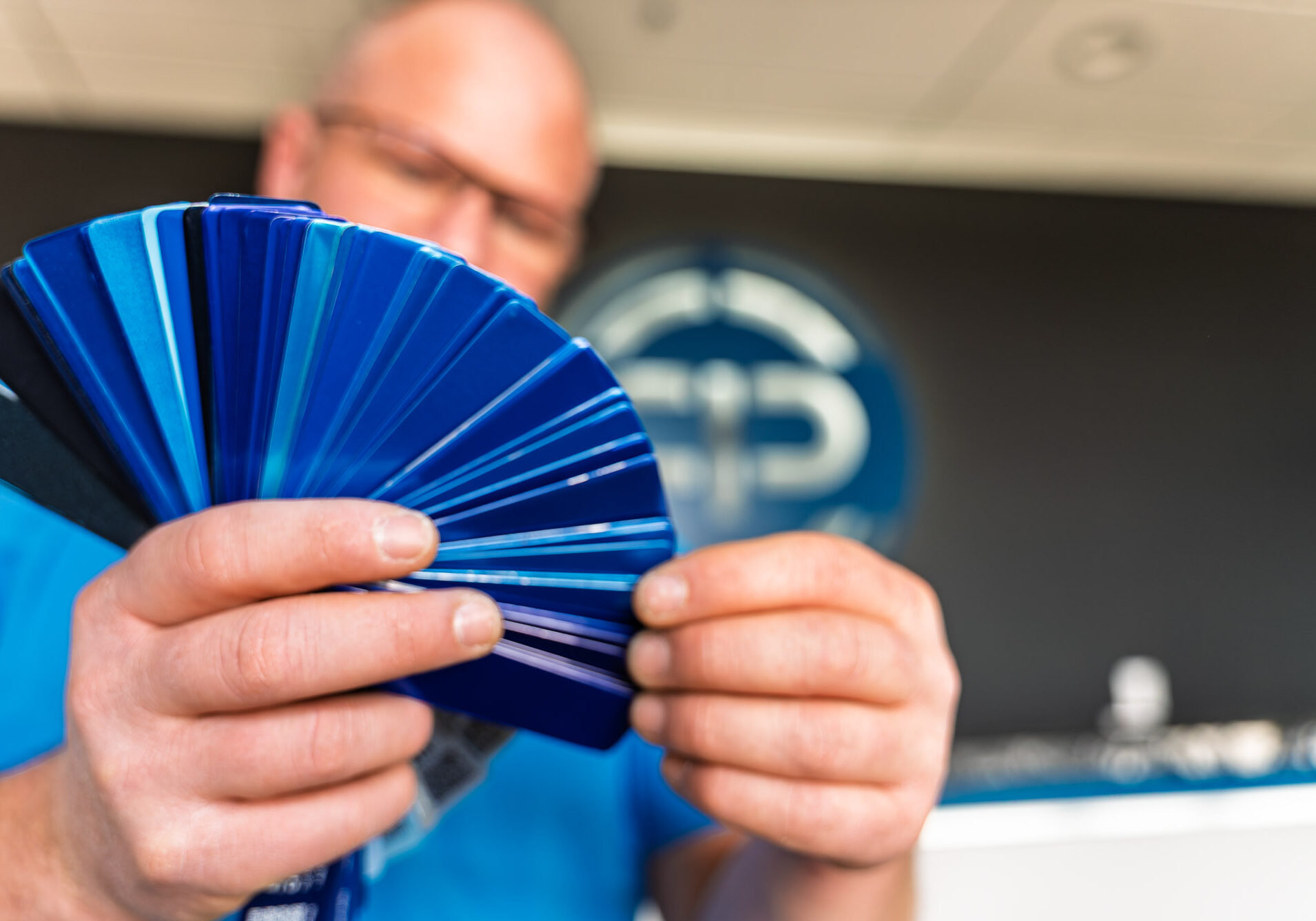 Man holding blue paint color swatches fan deck