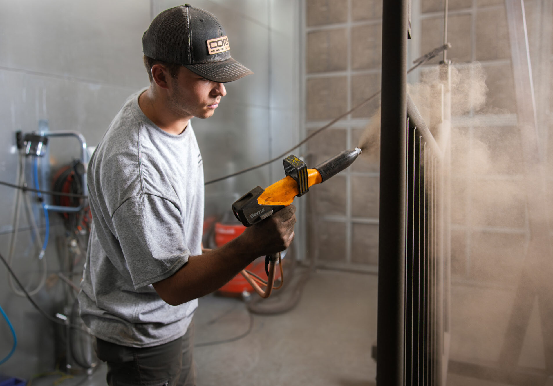 Worker using a spray gun for painting metal